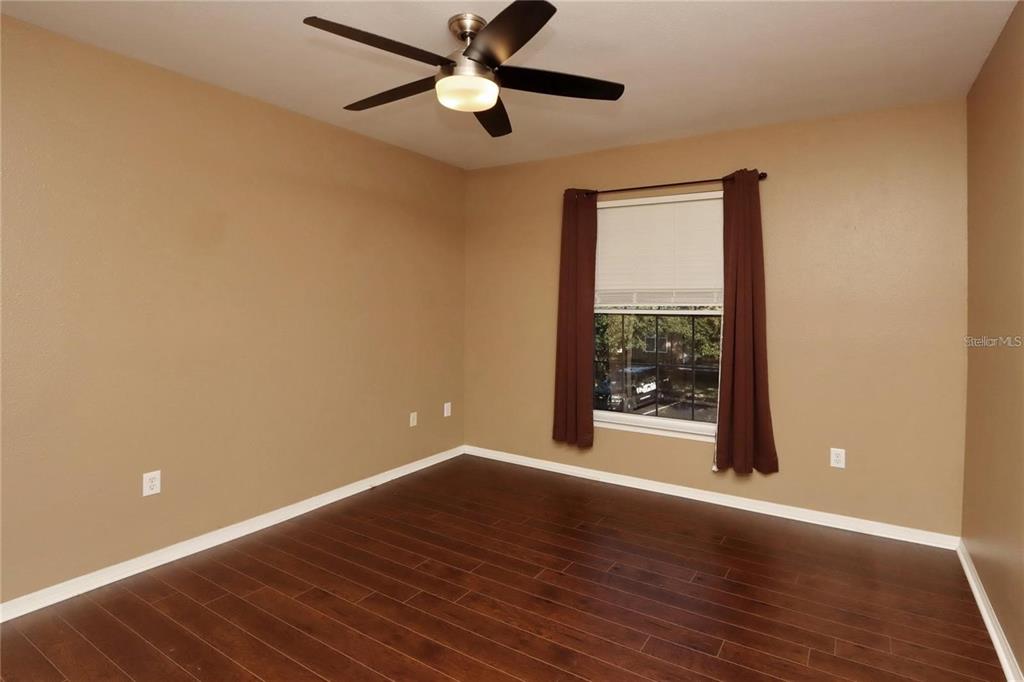 9918 Courtney Palms Boulevard, Unit 201 Tampa, FL 33619 - Photo 14 of 24 a view of an empty room with wooden floor and a window
