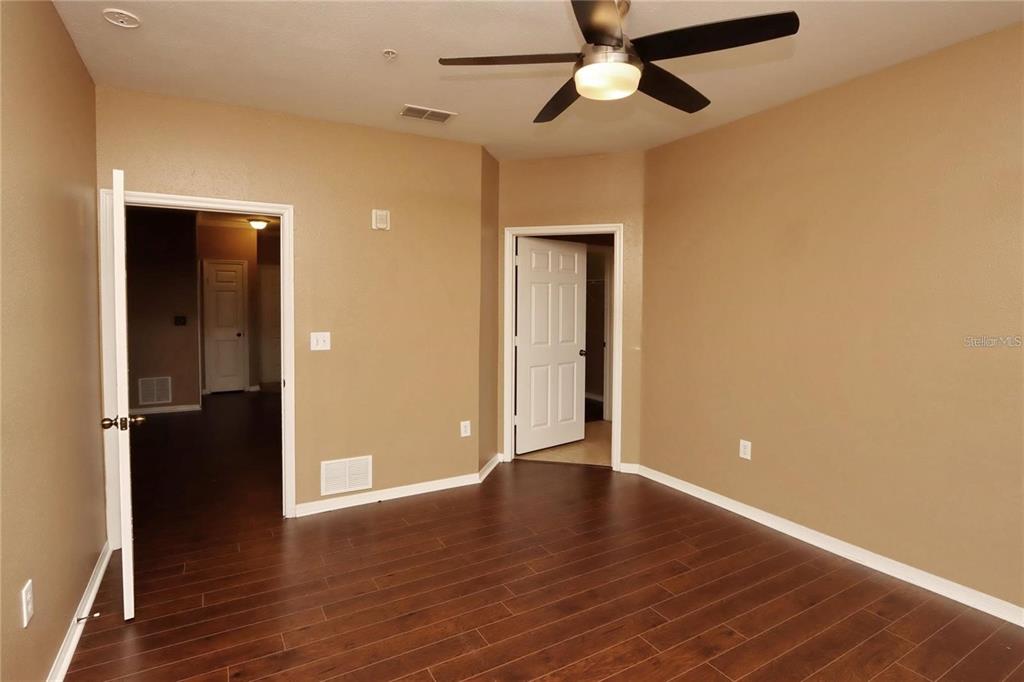 9918 Courtney Palms Boulevard, Unit 201 Tampa, FL 33619 - Photo 15 of 24 an empty room with wooden floor closet and a ceiling fan
