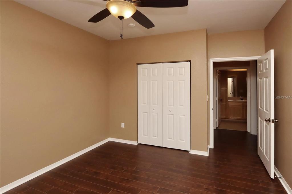 9918 Courtney Palms Boulevard, Unit 201 Tampa, FL 33619 - Photo 19 of 24 an empty room with wooden floor closet and windows