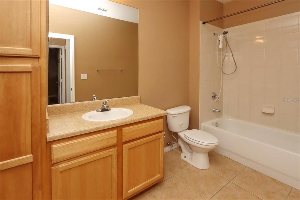 9918 Courtney Palms Boulevard, Unit 201 Tampa, FL 33619 - Photo 21 of 24 a bathroom with a granite countertop sink toilet and shower