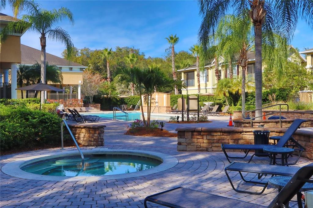 9918 Courtney Palms Boulevard, Unit 201 Tampa, FL 33619 - Photo 7 of 24 a swimming pool with outdoor seating and yard