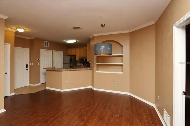 a view of a kitchen with wooden floor and a refrigerator