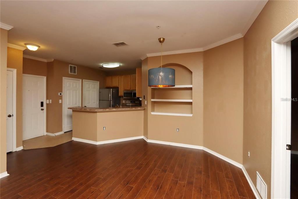 9918 Courtney Palms Boulevard, Unit 201 Tampa, FL 33619 - Photo 9 of 24 a view of a kitchen with wooden floor and a refrigerator