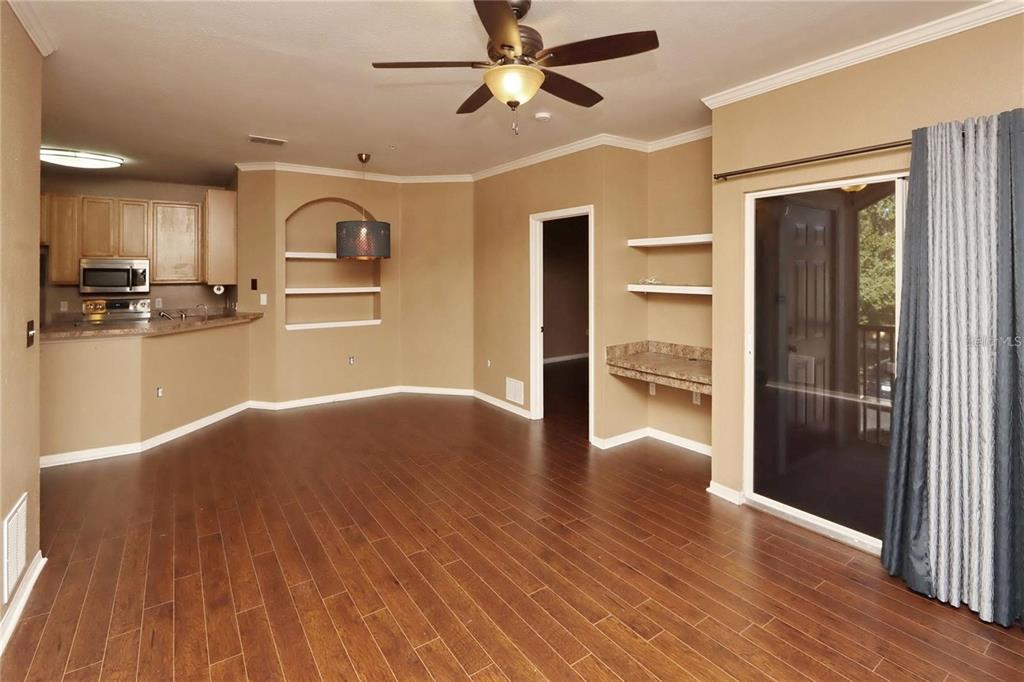 9918 Courtney Palms Boulevard, Unit 201 Tampa, FL 33619 - Photo 10 of 24 a view of a living room with wooden floor and a ceiling fan