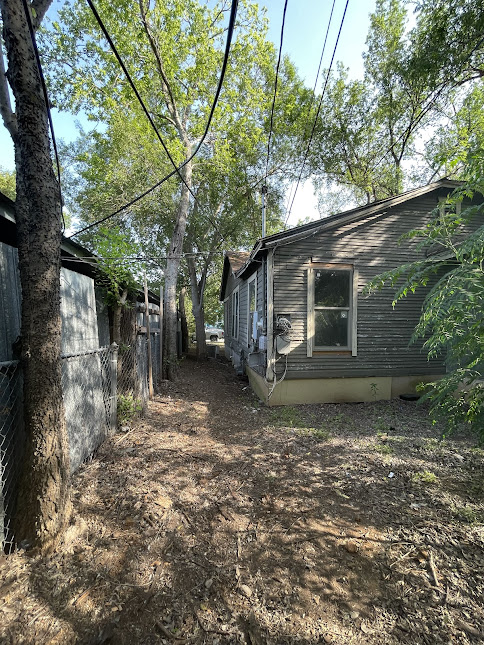 3208 East 16th Street Austin, TX 78721 - Photo 7 of 11 A rustic exterior with weathered siding and mature trees offers a private and natural setting.