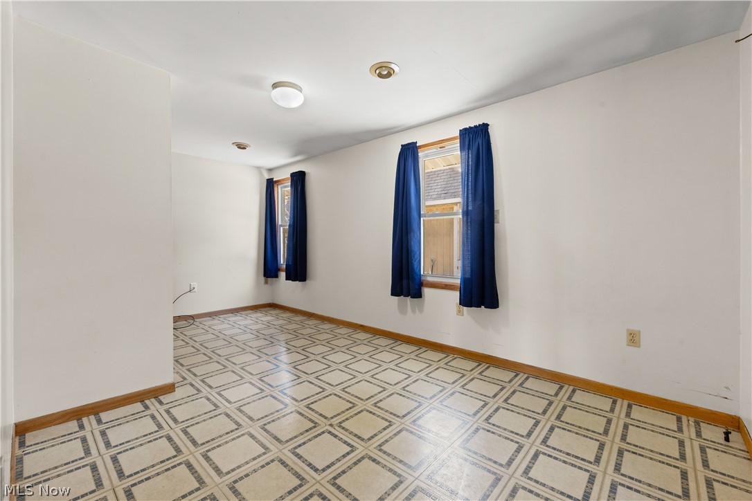 409 Edith Avenue Akron, OH 44312 - Photo 21 of 45 Spacious room featuring patterned tile flooring, white walls, and two windows