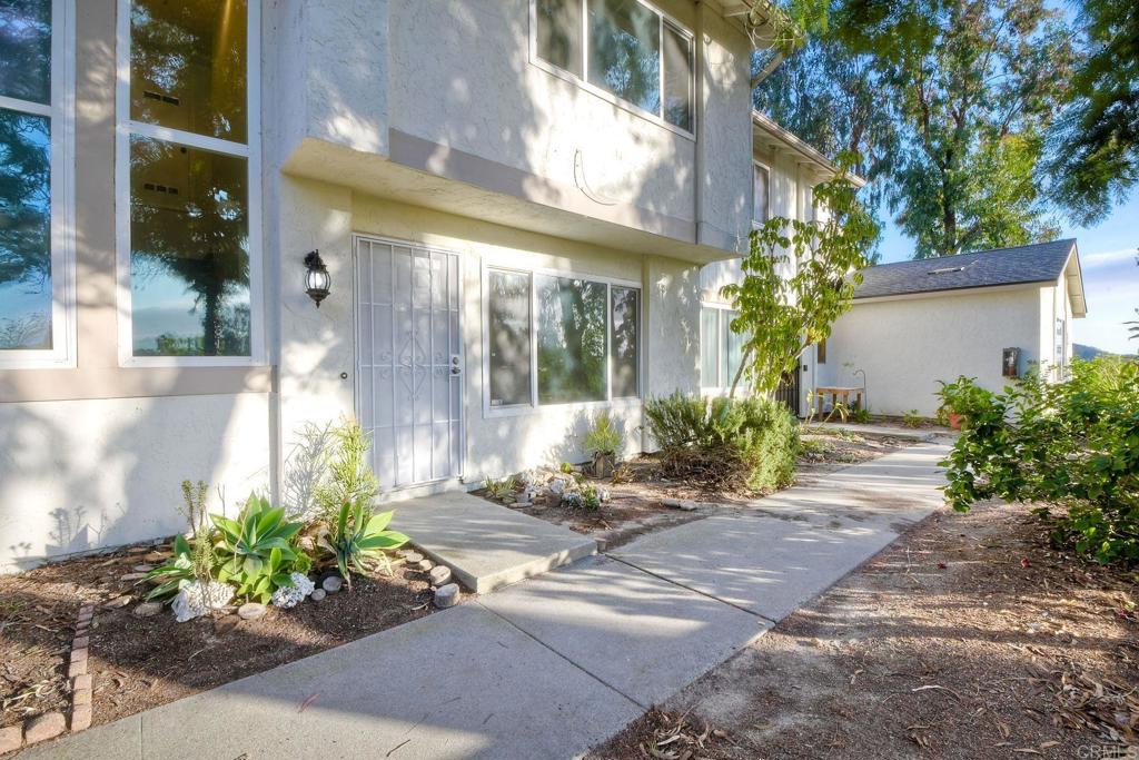 a front view of a house with a yard and potted plants