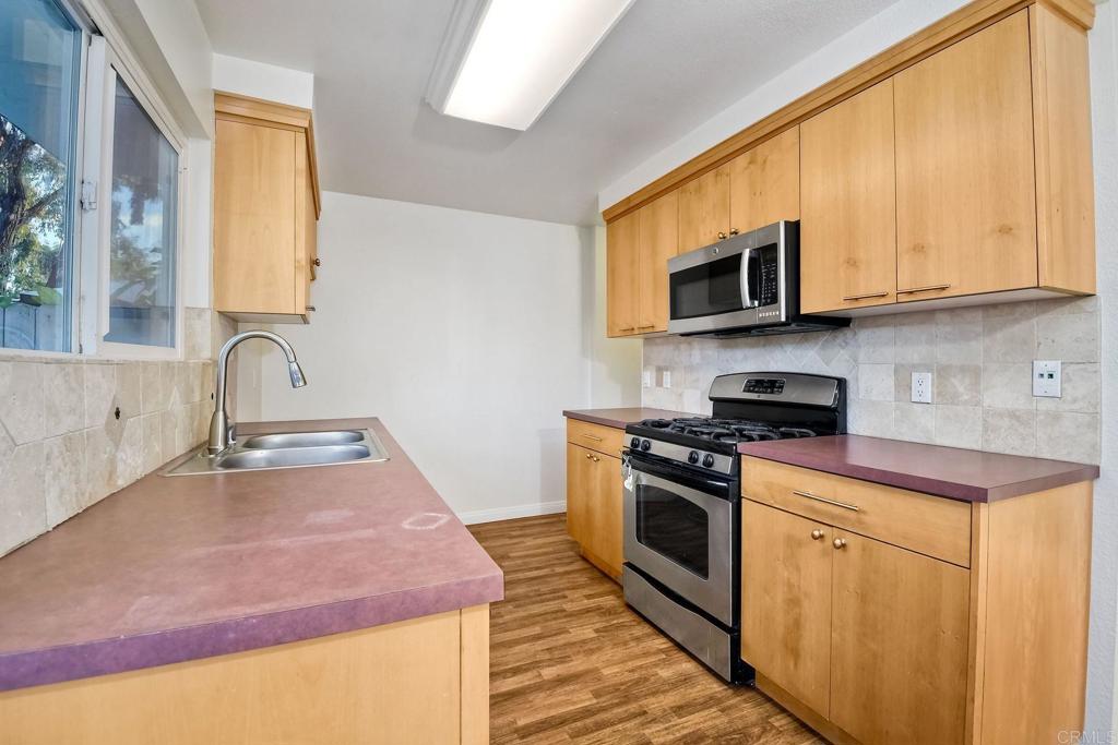 3605 Surfline Way Oceanside, CA 92056 - Photo 14 of 32 a kitchen with stainless steel appliances granite countertop a sink and a stove top oven