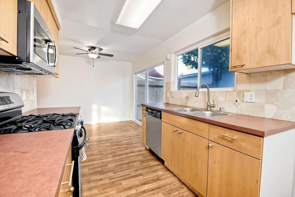 3605 Surfline Way Oceanside, CA 92056 - Photo 16 of 32 a kitchen that has a sink and a stove with wooden floor