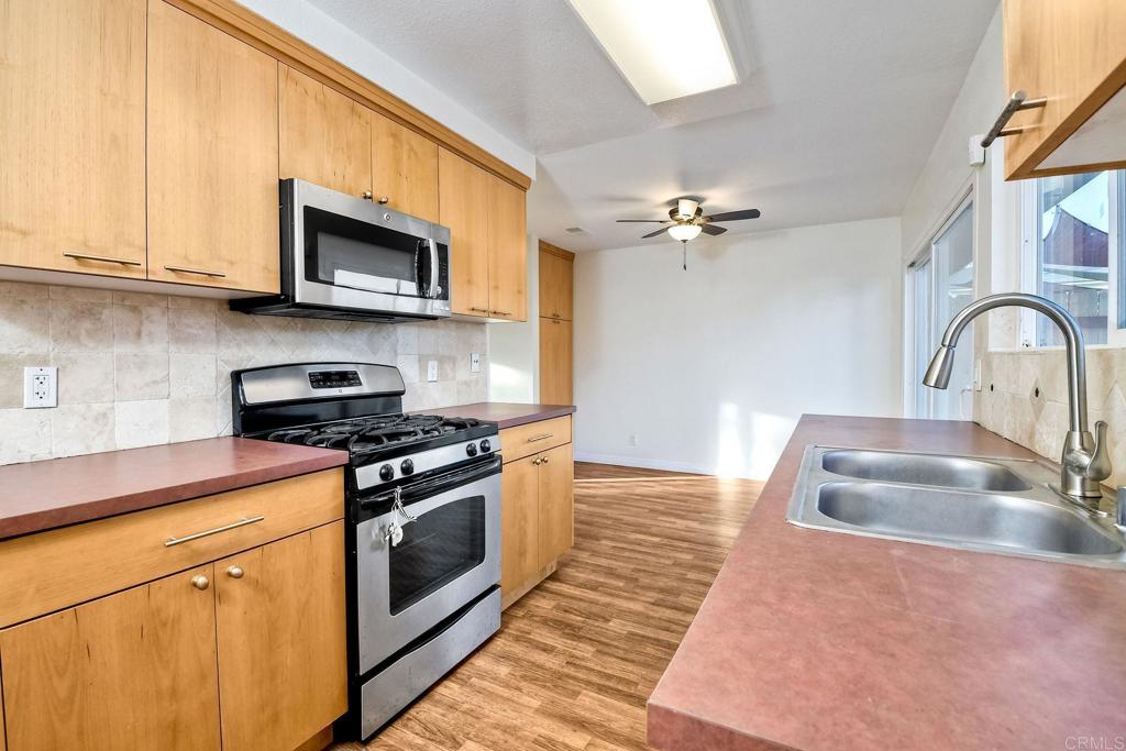 3605 Surfline Way Oceanside, CA 92056 - Photo 17 of 32 a kitchen with stainless steel appliances granite countertop a sink a stove a microwave and cabinets
