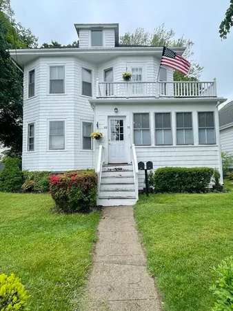 a front view of a house with a garden and yard