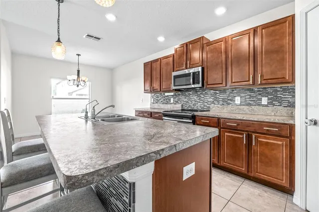 a kitchen with stainless steel appliances granite countertop a sink a microwave counter space and cabinets