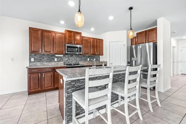 a kitchen with stainless steel appliances kitchen island granite countertop a stove a sink and a microwave