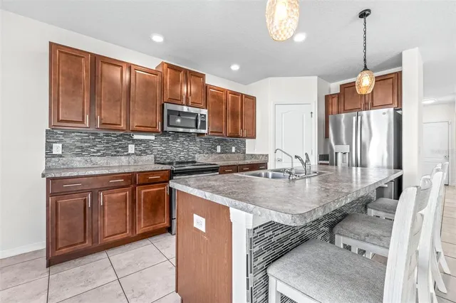 a kitchen with stainless steel appliances granite countertop a sink refrigerator and cabinets