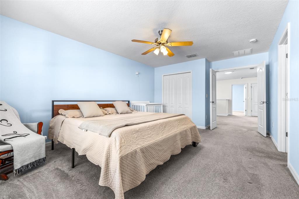 16713 Scenic Hill Way Wimauma, FL 33598 - Photo 25 of 52 a bed room with a bed and a chandelier