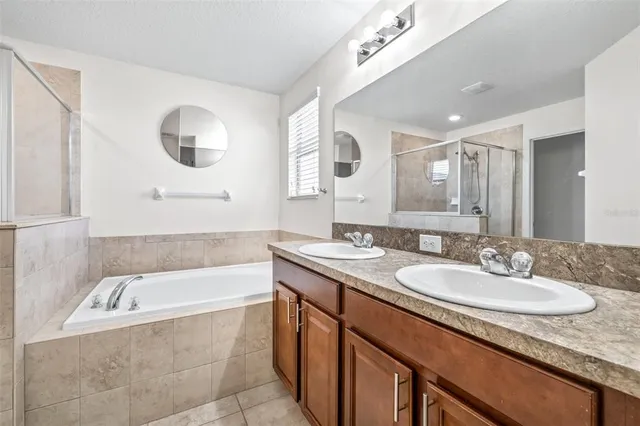 a bathroom with a granite countertop sink mirror and bathtub