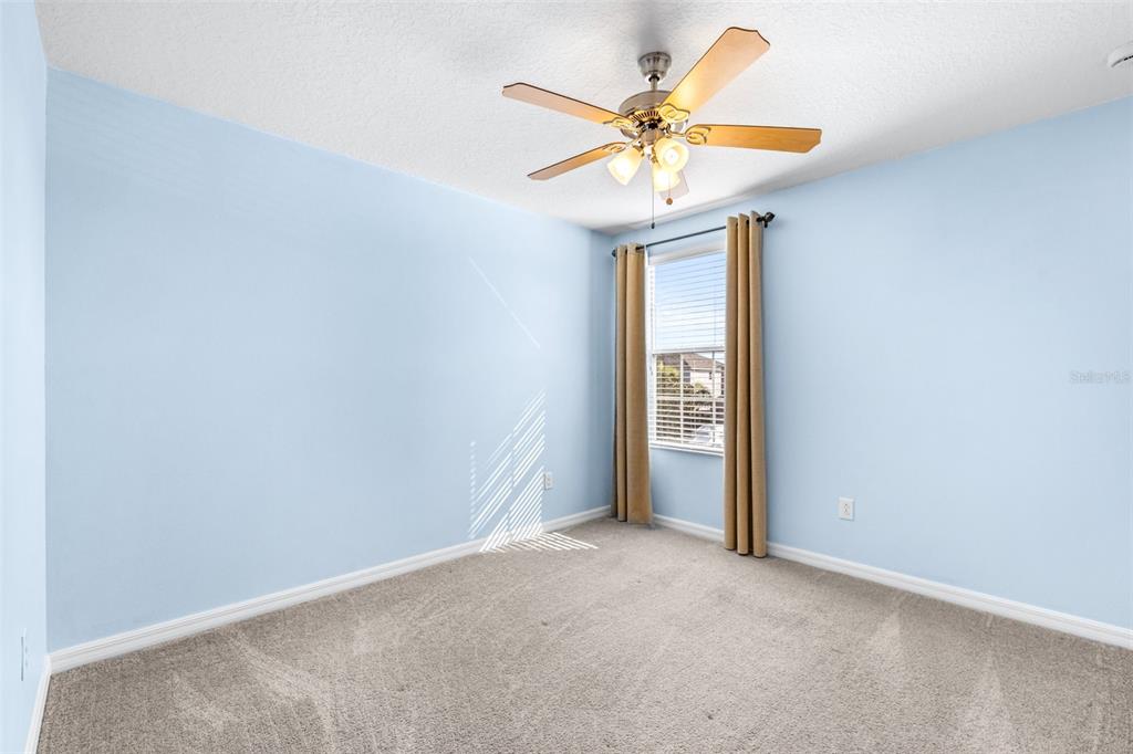 16713 Scenic Hill Way Wimauma, FL 33598 - Photo 34 of 52 an empty room with a window and a fan