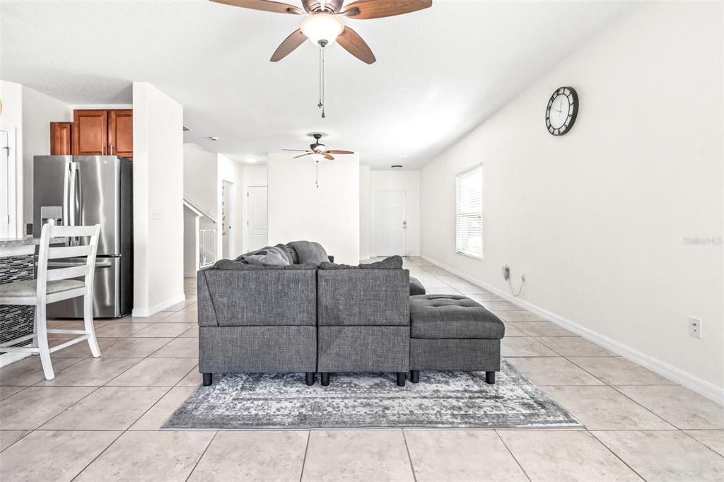 16713 Scenic Hill Way Wimauma, FL 33598 - Photo 8 of 52 a living room with a couch and a chandelier