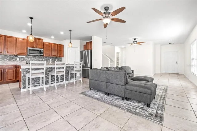 a living room with furniture a ceiling fan and a rug