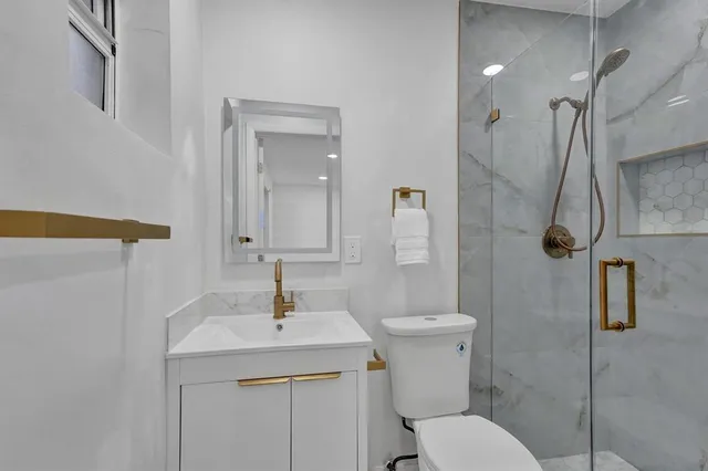 a bathroom with a sink a toilet and shower