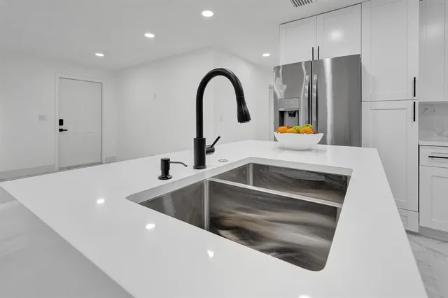 a kitchen with a refrigerator and a sink