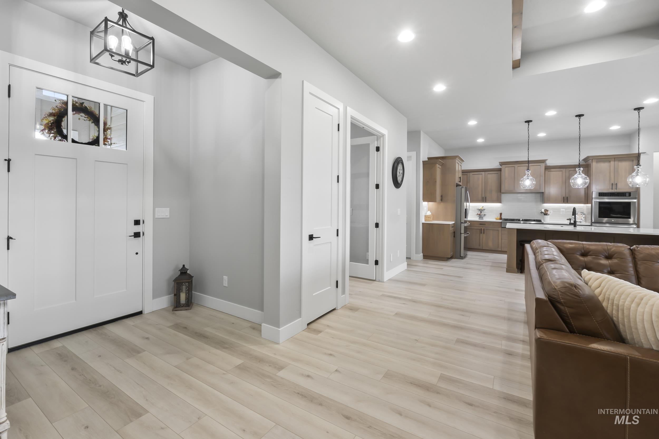 24696 Regal Road Middleton, ID 83644 - Photo 8 of 24 Foyer entrance featuring light wood finished floors and hanging lights