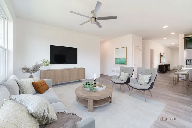 a living room with furniture a flat screen tv and a window