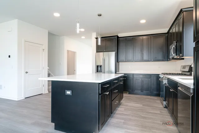 a kitchen with kitchen island granite countertop wooden cabinets and white appliances