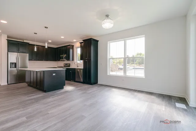 a view of kitchen with stainless steel appliances granite countertop a stove and a refrigerator