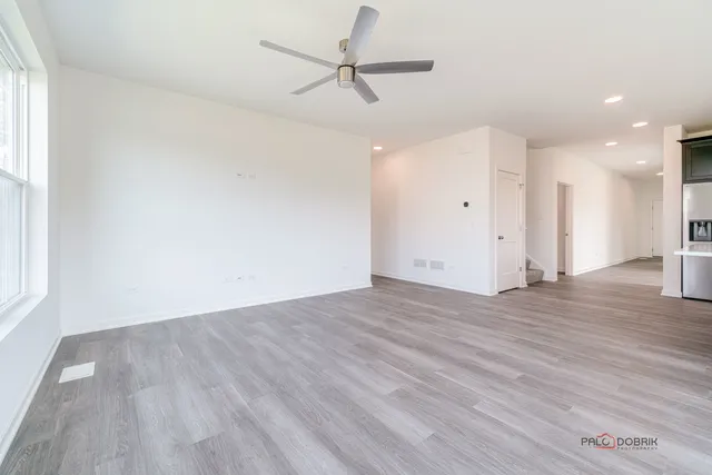 a view of a room with wooden floor and a ceiling fan