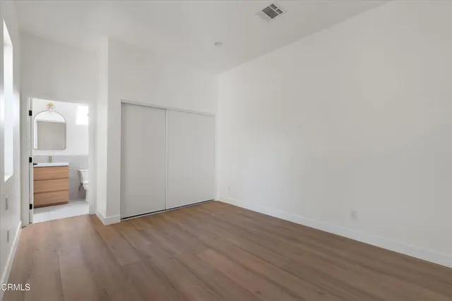 a view of a room with wooden floor and a ceiling fan
