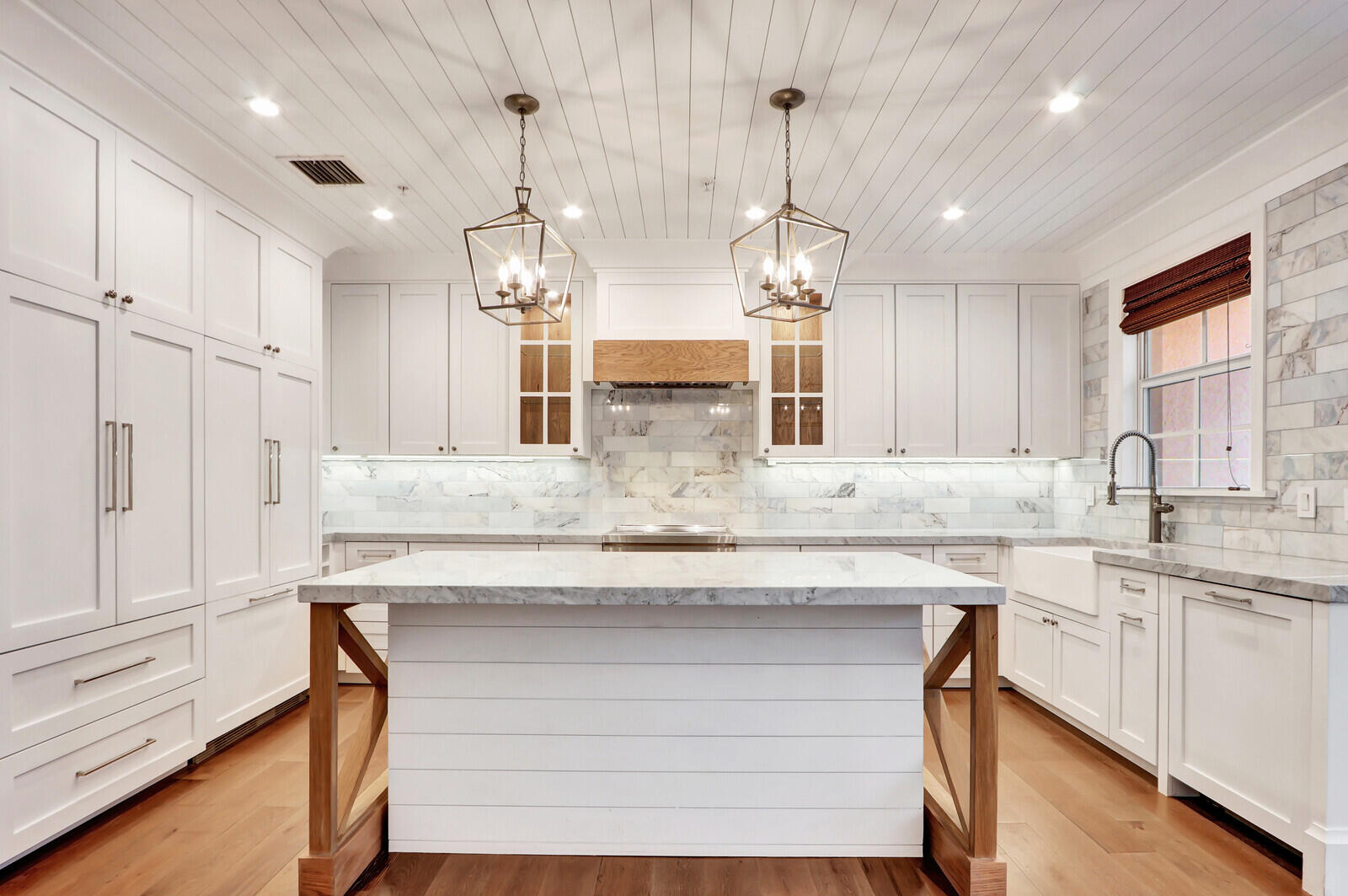 a kitchen with kitchen island granite countertop a table chairs in it and wooden floors