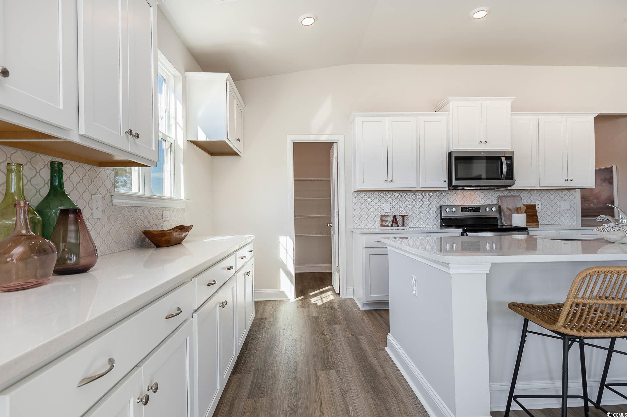 187 Bjorn Way Loris, SC 29569 - Photo 13 of 40 Kitchen featuring decorative backsplash, a kitchen breakfast bar, light countertops, vaulted ceiling, and recessed lighting