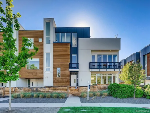 a front view of a residential apartment building with a yard and plants