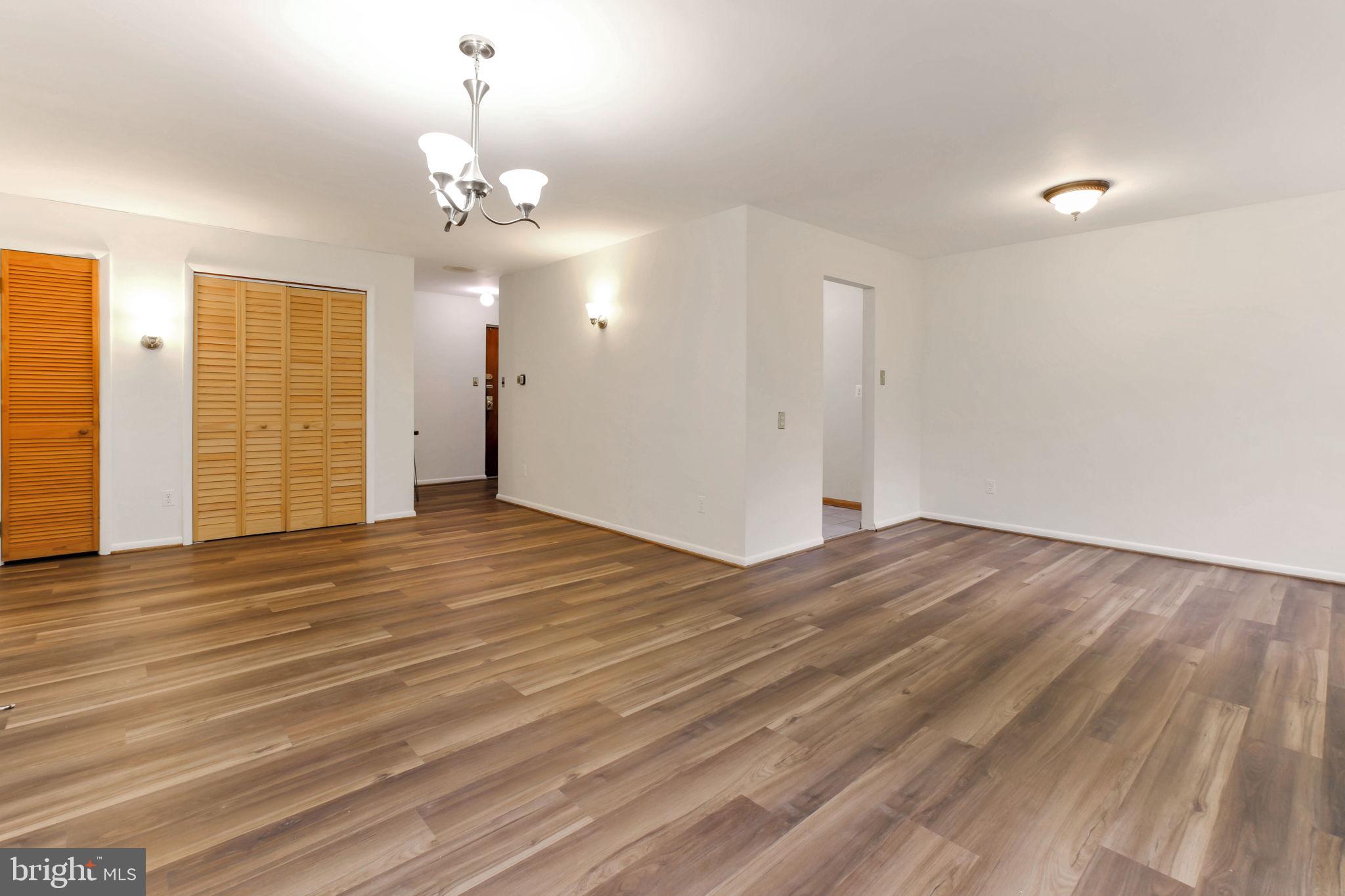 5101 8th Road South, Unit 102 Arlington, VA 22204 - Photo 14 of 19 an empty room with wooden floor chandelier and windows