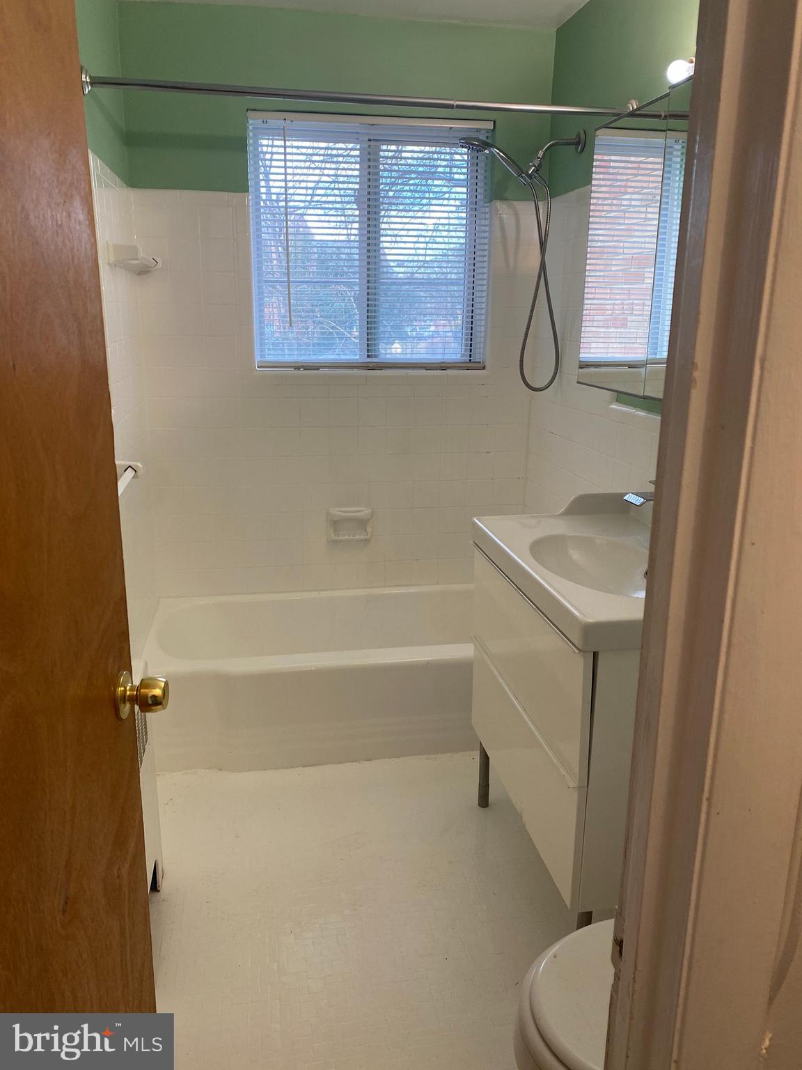 5101 8th Road South, Unit 102 Arlington, VA 22204 - Photo 18 of 22 a bathroom with a granite countertop shower a toilet and a sink