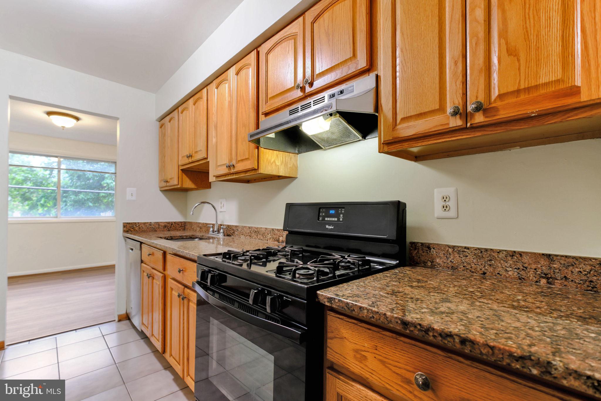 5101 8th Road South, Unit 102 Arlington, VA 22204 - Photo 4 of 19 a kitchen with stainless steel appliances granite countertop a stove a sink and a microwave