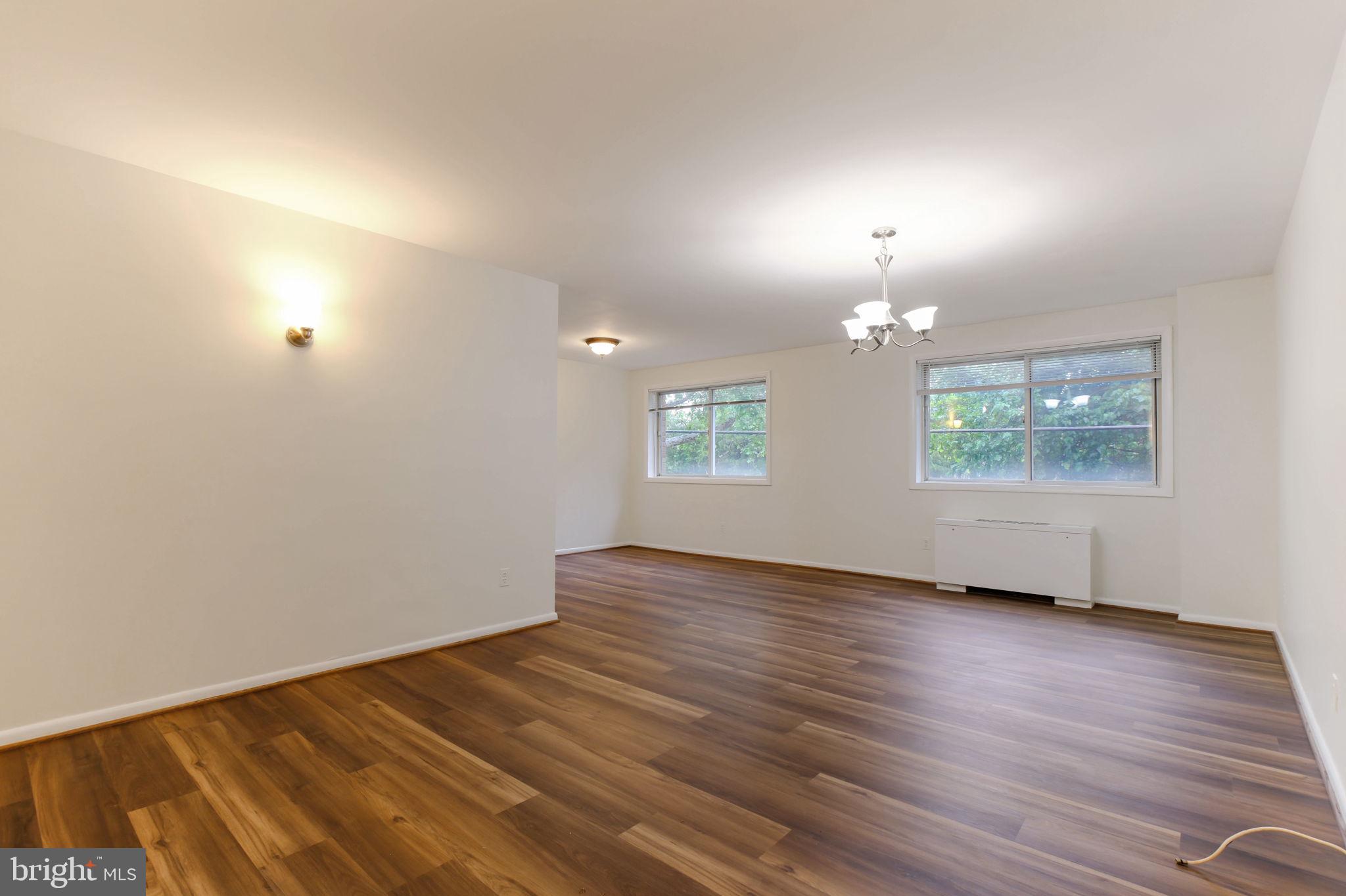 5101 8th Road South, Unit 102 Arlington, VA 22204 - Photo 6 of 19 an empty room with wooden floor chandelier and windows