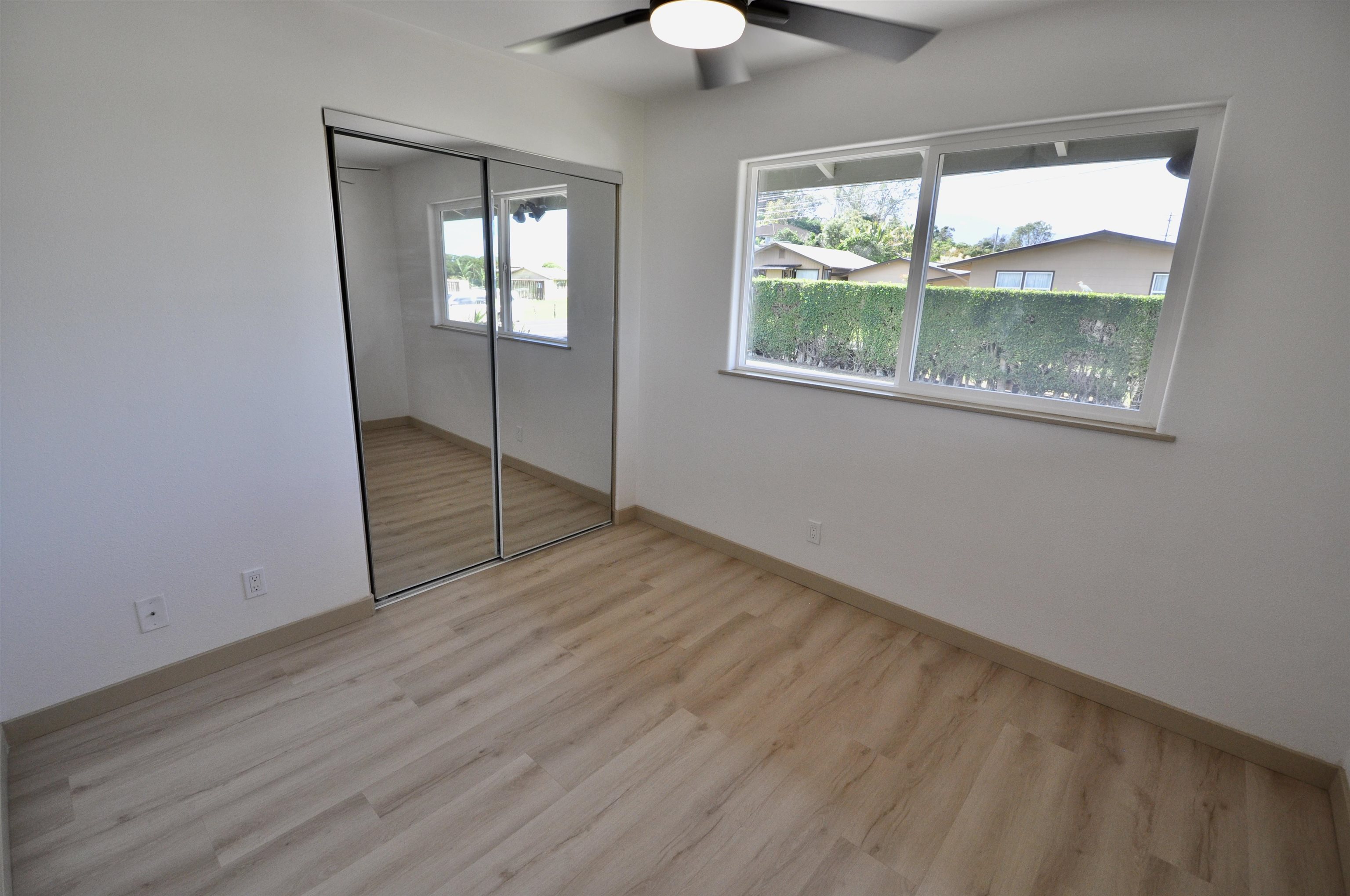 2835 Kaupakalua Road Haiku, HI 96708 - Photo 14 of 31 an empty room with wooden floor and windows