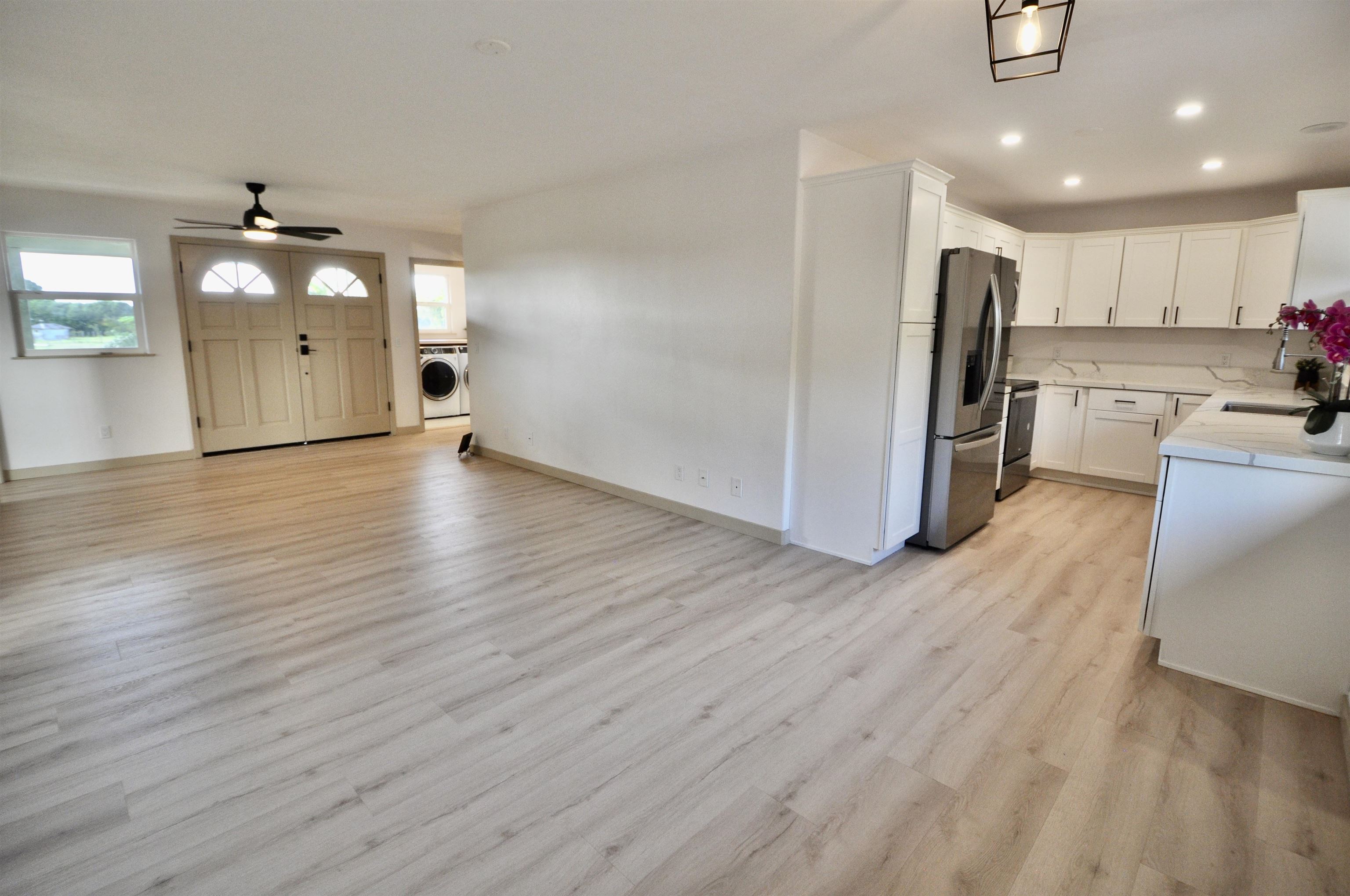 2835 Kaupakalua Road Haiku, HI 96708 - Photo 4 of 31 a view of a kitchen with a sink and dishwasher a refrigerator with wooden floor