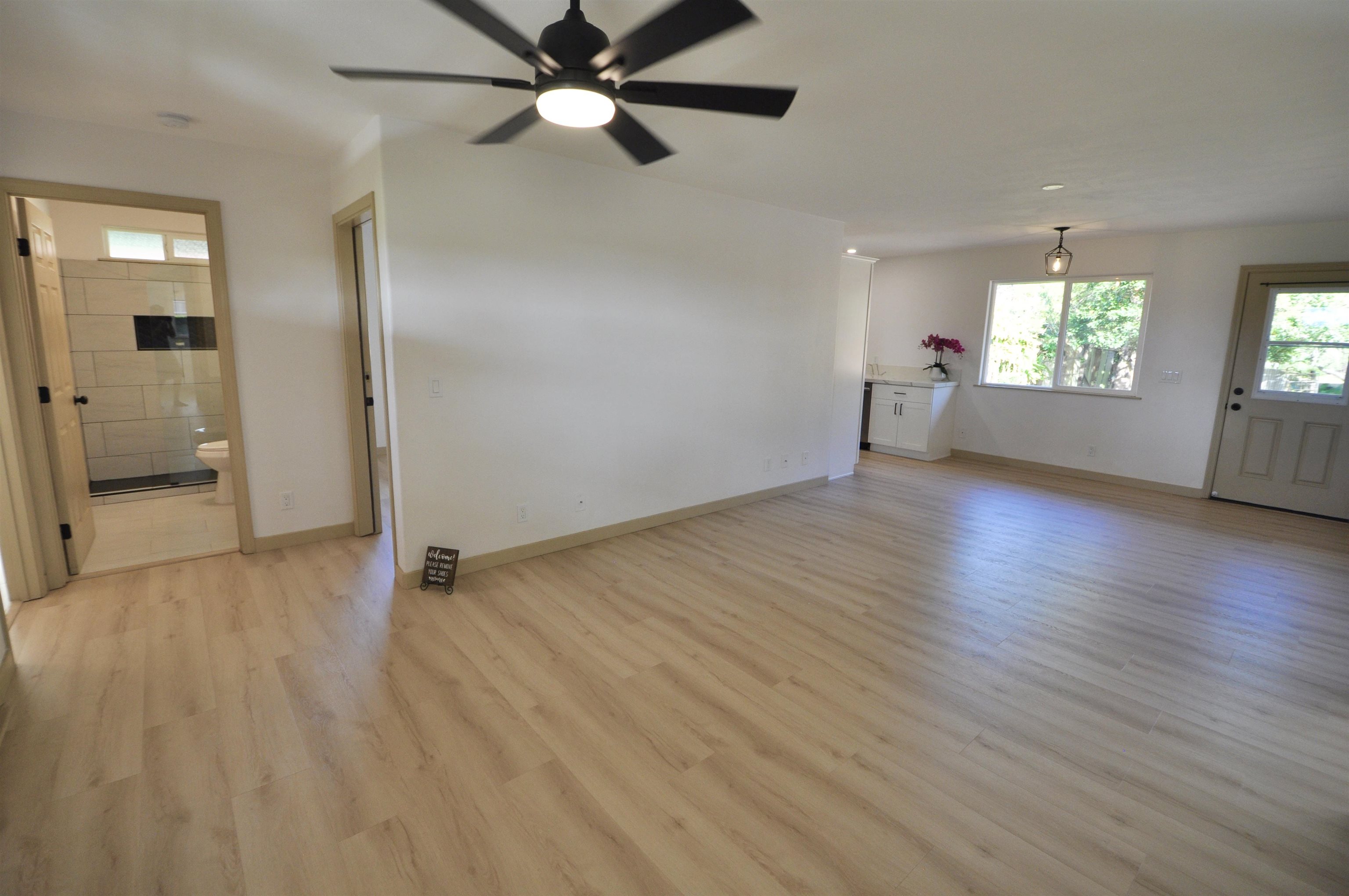 2835 Kaupakalua Road Haiku, HI 96708 - Photo 6 of 31 an empty room with wooden floor fan and windows