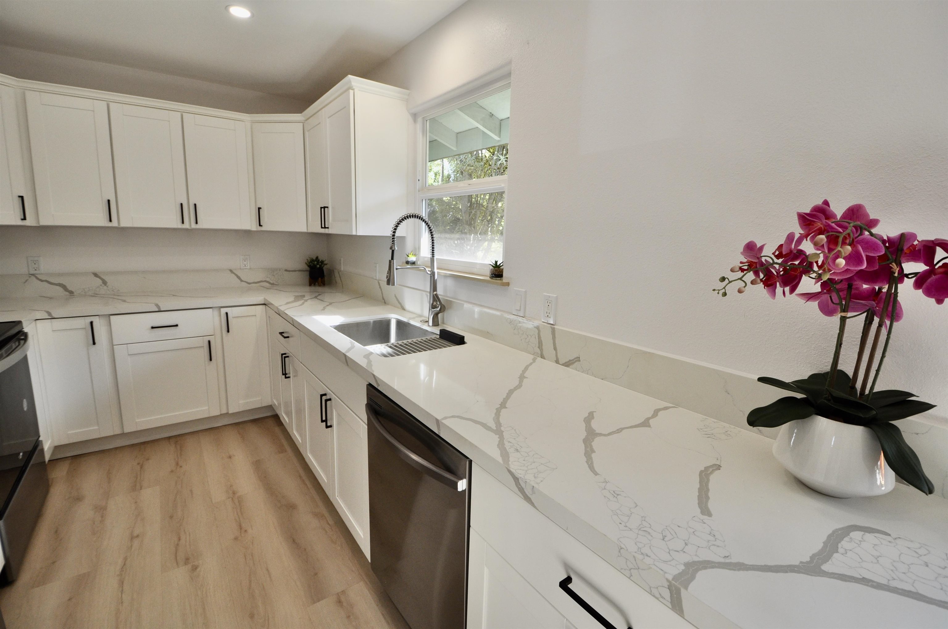 2835 Kaupakalua Road Haiku, HI 96708 - Photo 8 of 31 a kitchen with a sink dishwasher stove and white cabinets with wooden floor