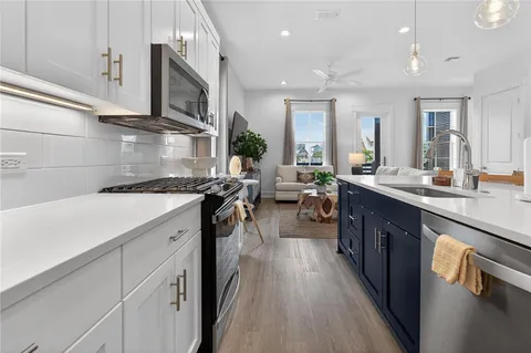 a kitchen with stainless steel appliances granite countertop a lot of counter space and wooden floors