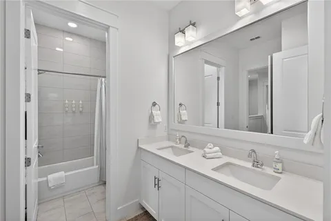 a bathroom with a shower sink vanity and mirror
