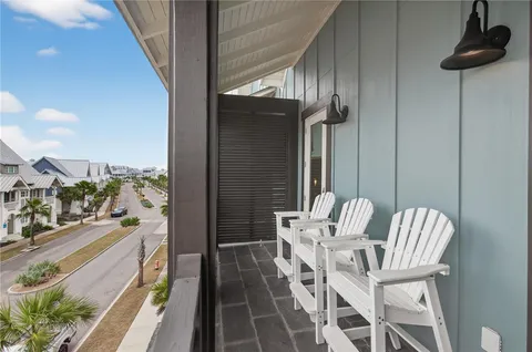 a balcony with chairs and view of living room