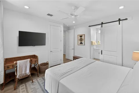 a bedroom with a bed tv and a window