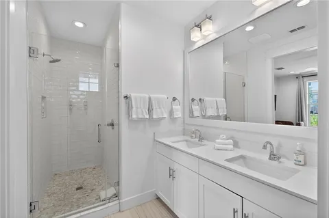 a bathroom with a shower sink vanity and mirror