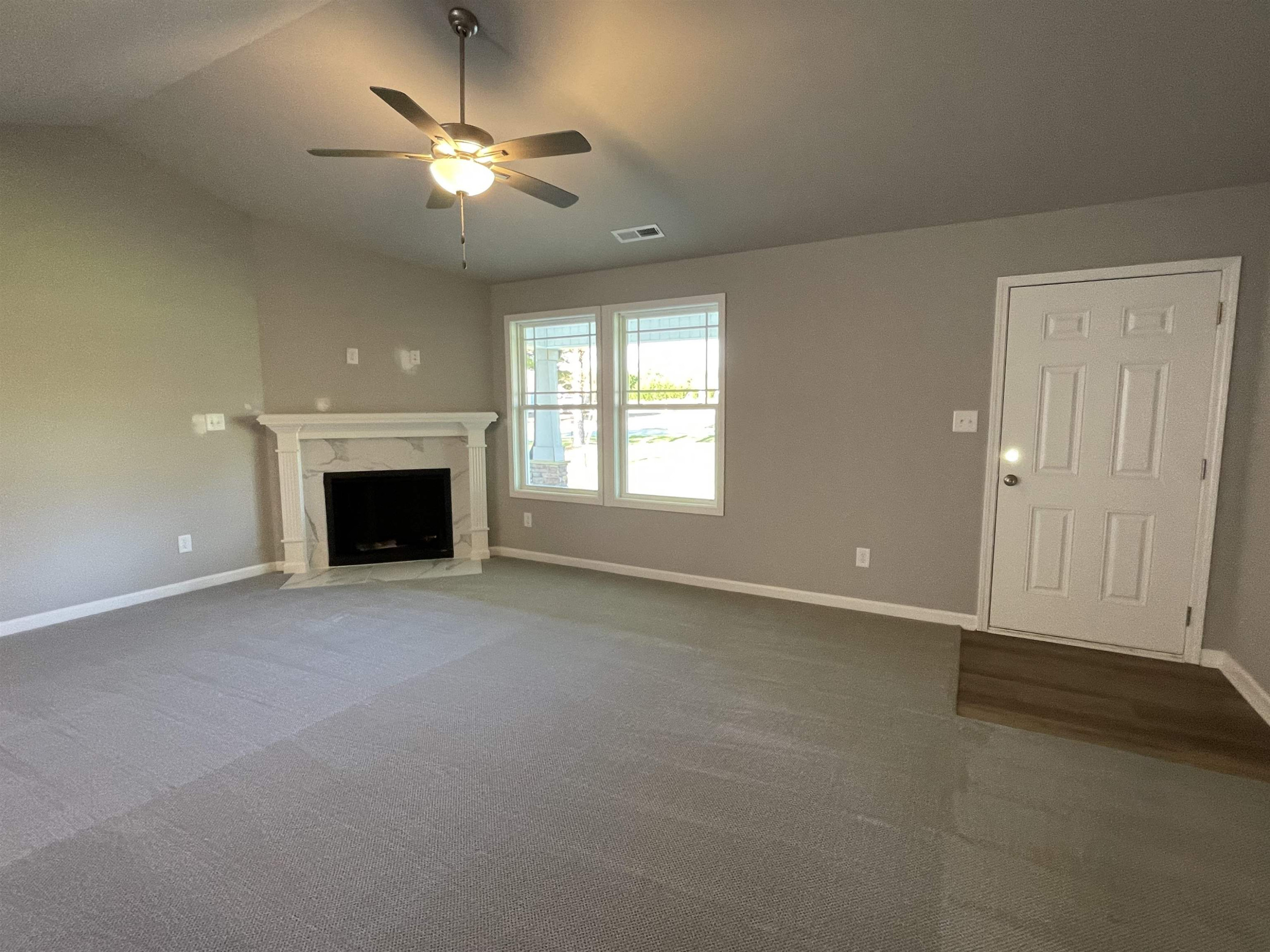 496 Roberts Road Willow Spring, NC 27592 - Photo 3 of 15 an empty room with fireplace and fan