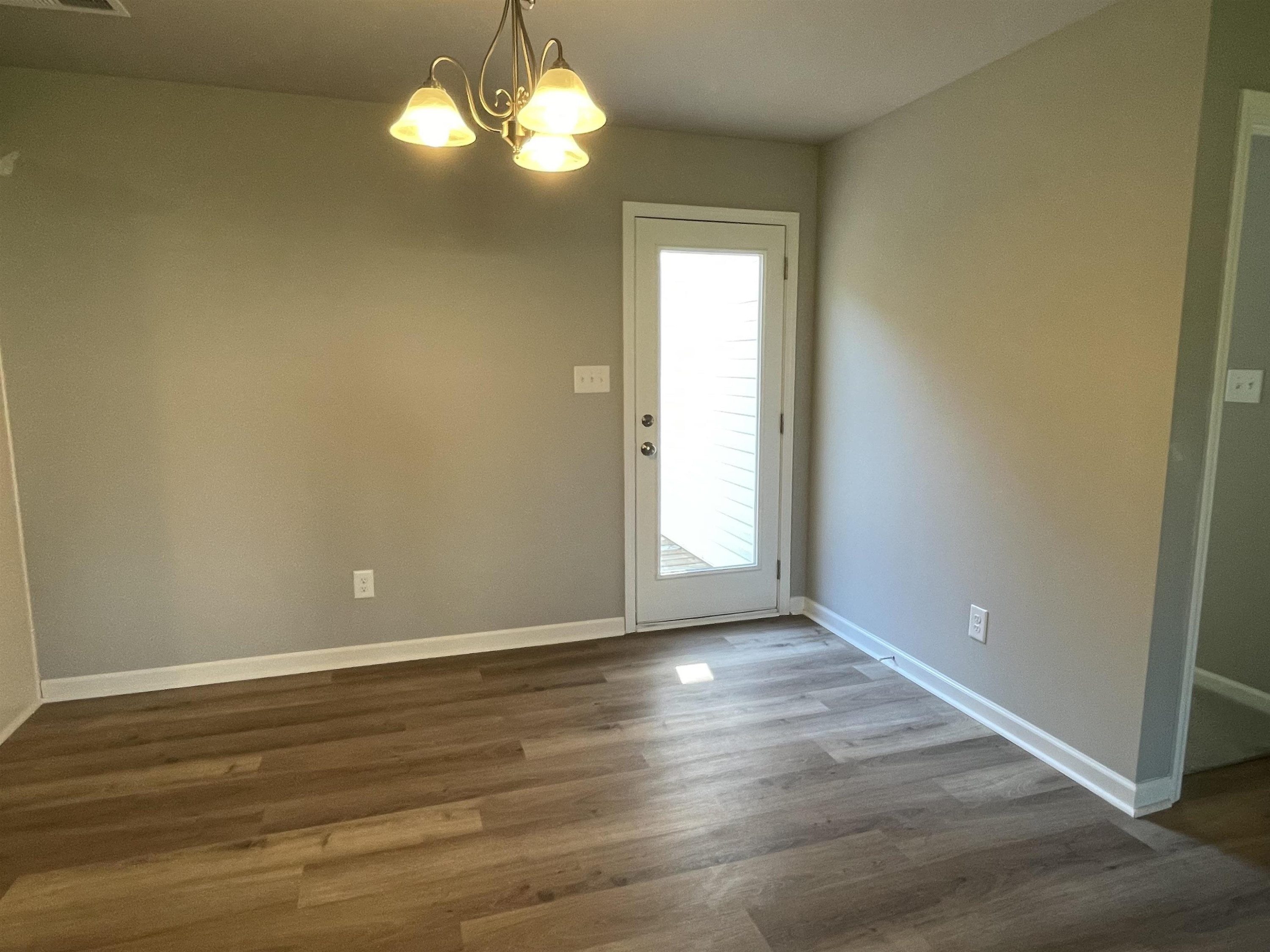 496 Roberts Road Willow Spring, NC 27592 - Photo 5 of 15 an empty room with wooden floor and windows