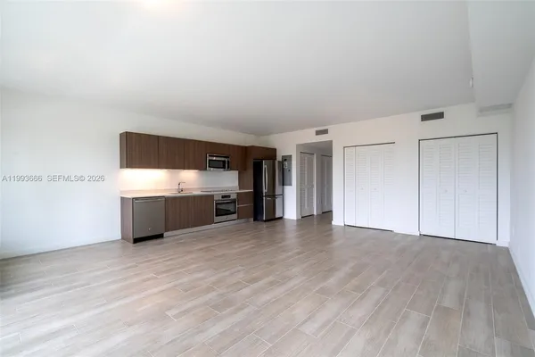 a view of a kitchen with a sink and a refrigerator